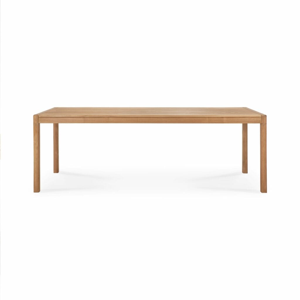 Une table à manger en teck sur fond blanc.
