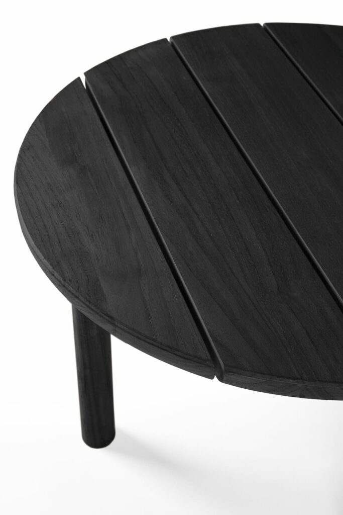 Une table basse de jardin teintée noir avec un plateau à lattes.