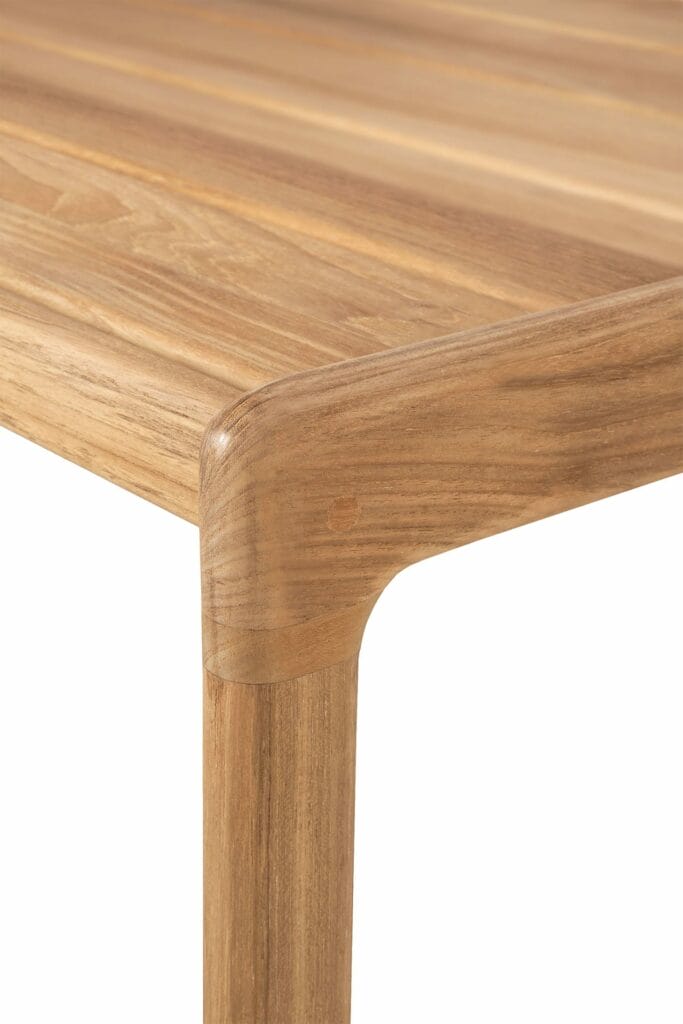 Un gros plan d’une table à manger en bois teinté noir.