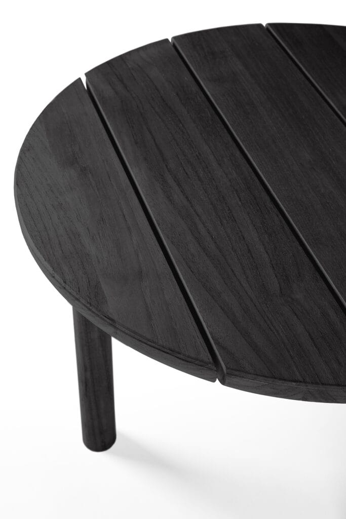 Une table basse ronde noire sur fond blanc.