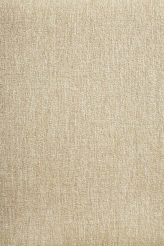 Image en gros plan d'un coussin en tissu beige sur une chaise de jardin.