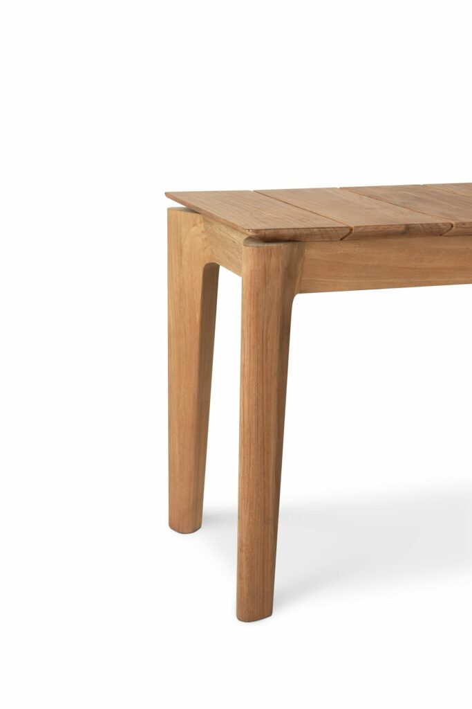 Une table en bois à deux pieds sur fond blanc en teck naturel.