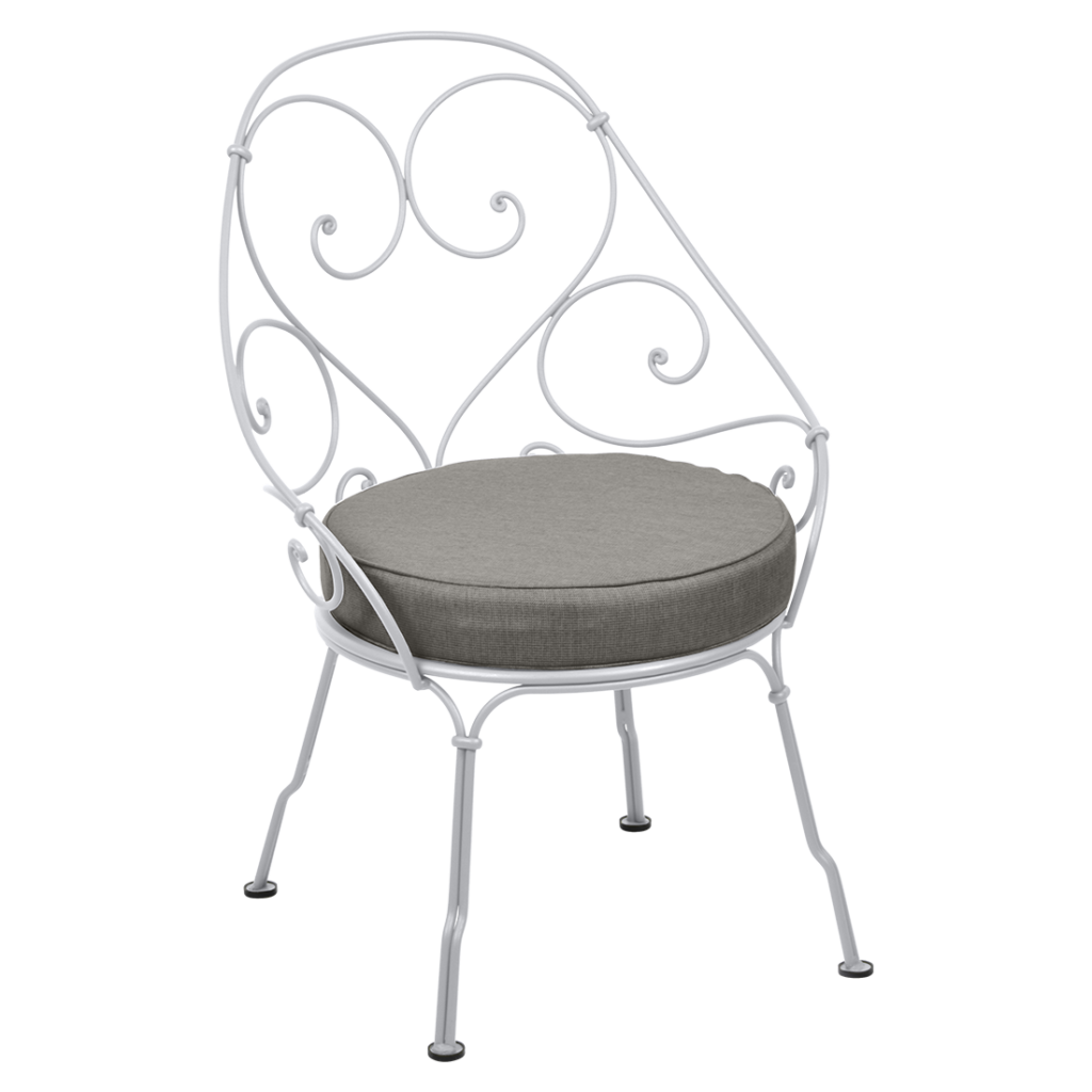 Une chaise en fer forgé blanc avec un coussin gris datant des années 1900.