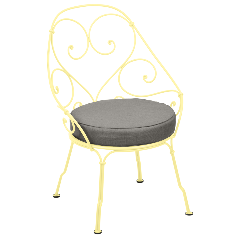 Chaise en fer forgé jaune avec un coussin gris, rappelant le design du Fauteuil Cabriolet des années 1900.