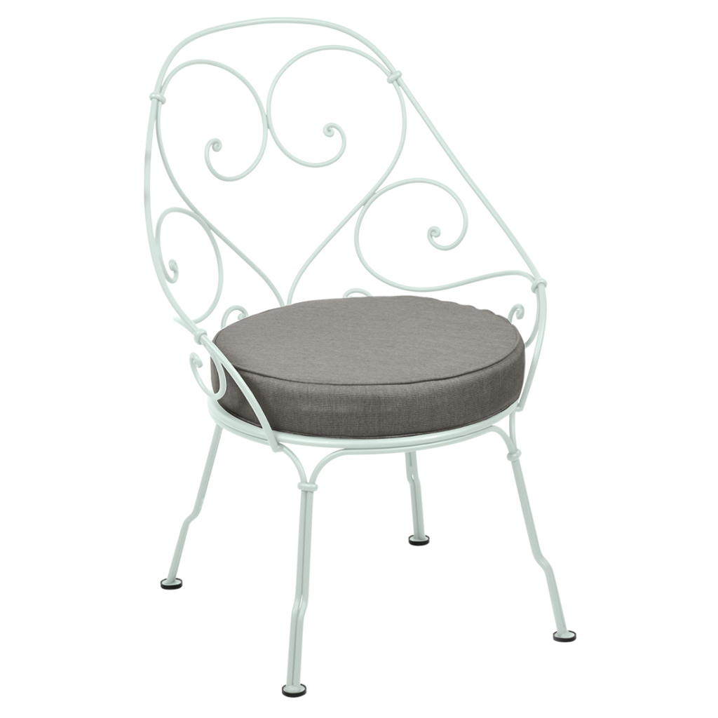 Une chaise en fer forgé blanc avec un coussin gris, parfaite pour se prélasser en extérieur.