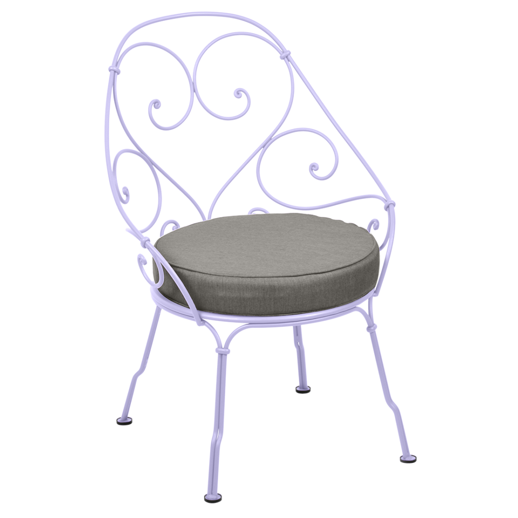 Une chaise en fer forgé blanc avec un coussin gris datant de 1900.