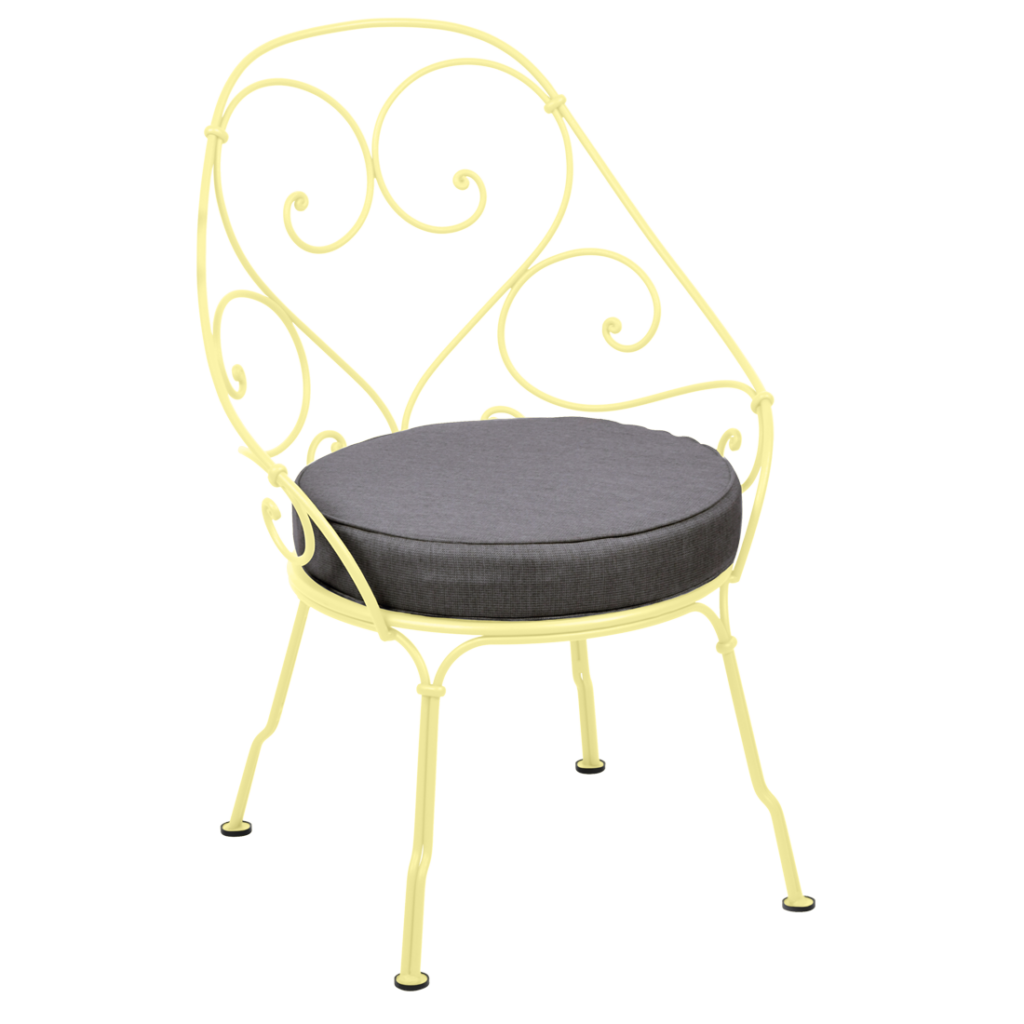 Un fauteuil jaune des années 1900 avec un coussin gris.