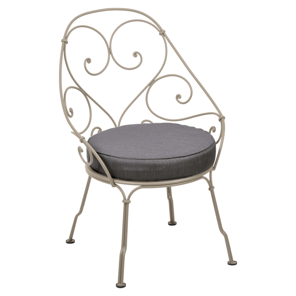 Une chaise en fer forgé des années 1900 avec un coussin gris.