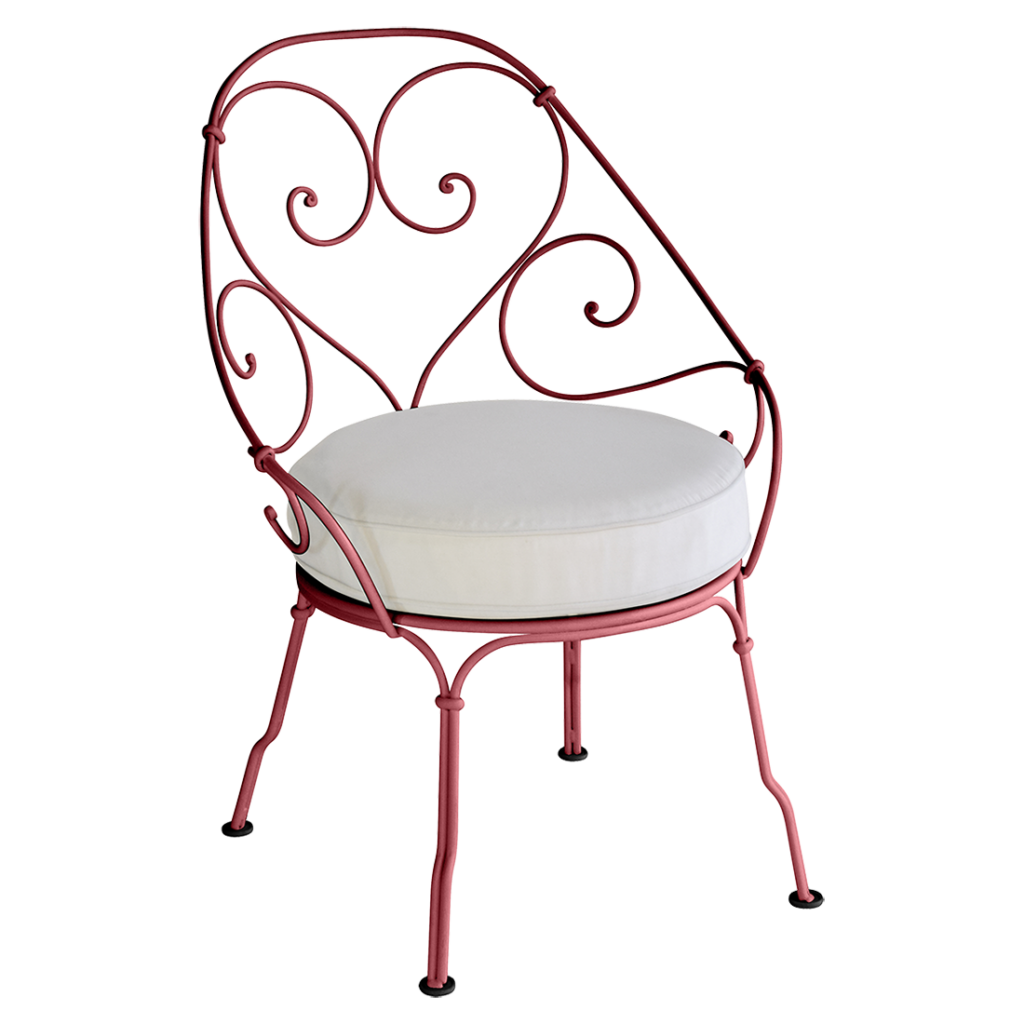 Une chaise Fauteuil Cabriolet en fer forgé rouge avec un coussin blanc datant de 1900.