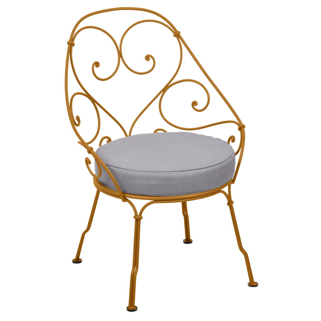 Une chaise en fer forgé avec un coussin gris datant de 1900.