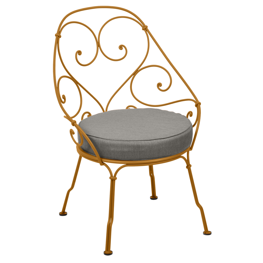 Un fauteuil des années 1900 avec un coussin gris en fer forgé.