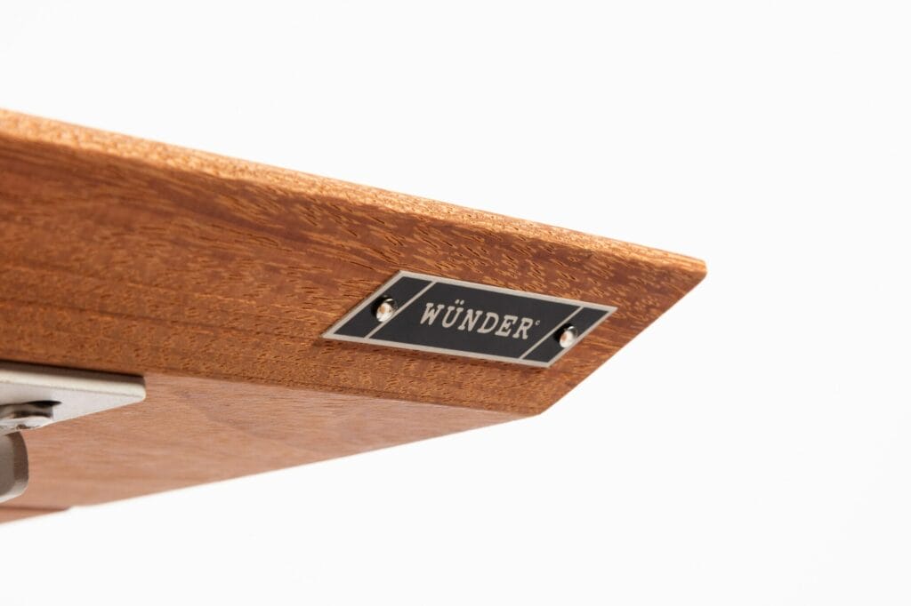 Presse-papiers en bois avec une étiquette en métal indiquant « wunder » sur un fond gris clair.