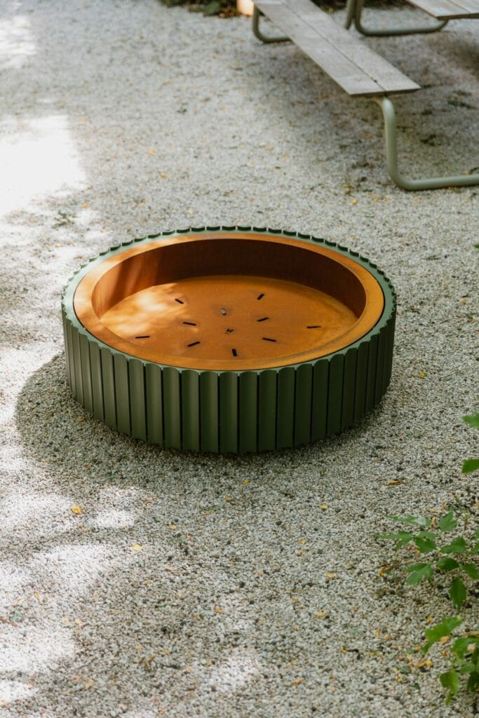 Trampoline d'extérieur circulaire, ø105cm, affleurant au sol entouré de graviers et d'Acier Corten.