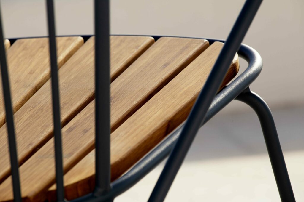 Gros plan d'une chaise à bascule Paon moderne avec des lattes en bois et une structure en métal.