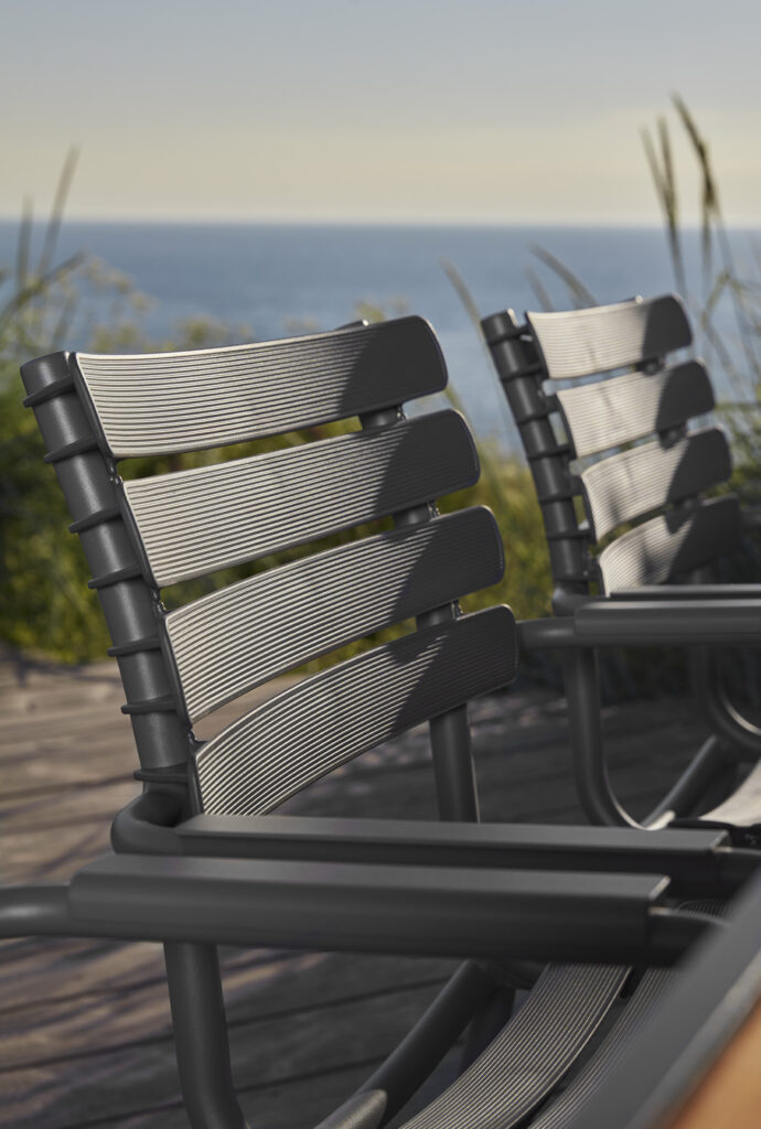Chaises de salle à manger ReCLIPS bleu ciel d'extérieur donnant sur une vue panoramique sur l'océan, conçues dans un accoudoir en bambou accueillant.