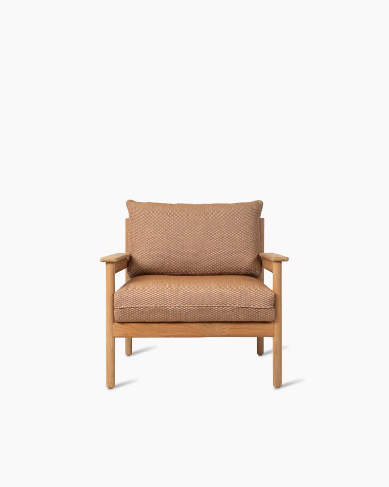Un fauteuil lounge Oda moderne en bois avec un siège et un dossier en rotin tressé, doté d'un coussin texturé doux, isolé sur un fond blanc.