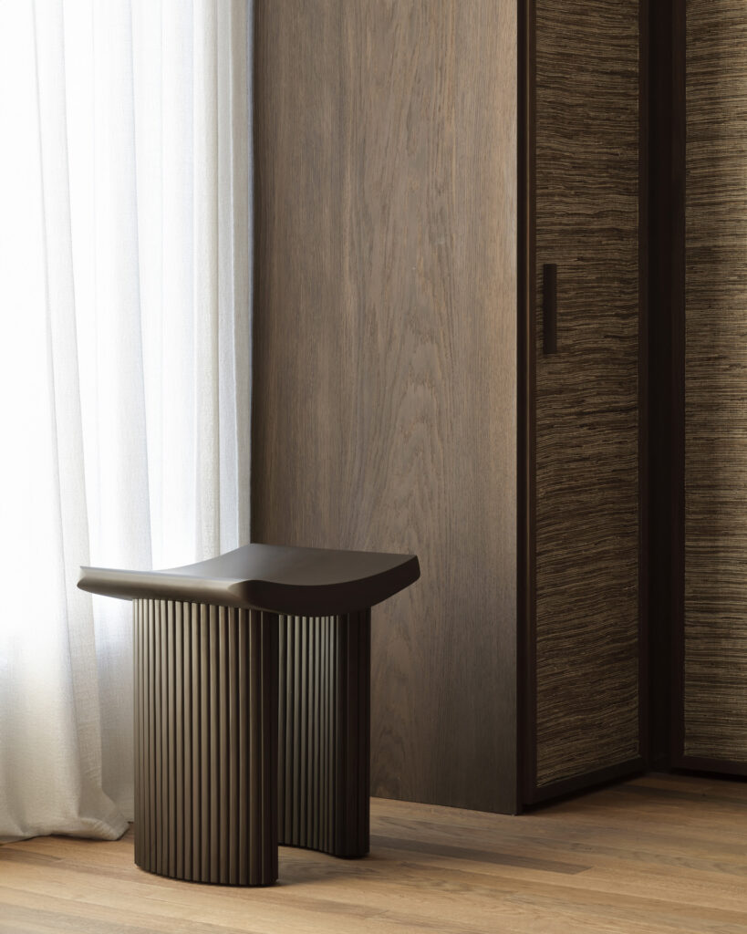 Un tabouret Roller Max moderne de couleur marron foncé - acajou verni - marron foncé avec un design nervuré est placé dans un coin à côté d'une armoire en bois et de rideaux blancs dans une pièce au parquet en bois d'acajou verni.