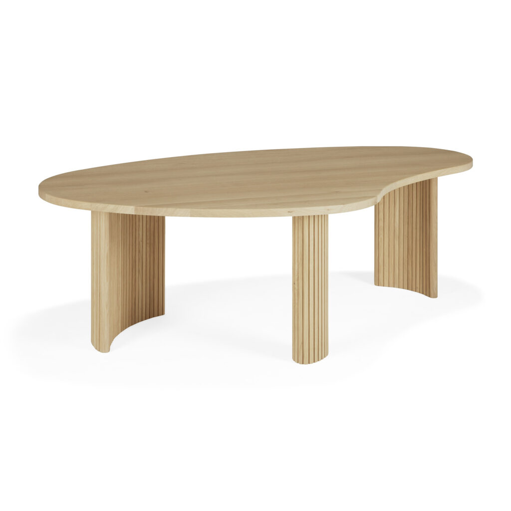 Une table basse en bois avec un plateau en forme de boomerang et trois pieds nervurés et courbés, sur un fond blanc.