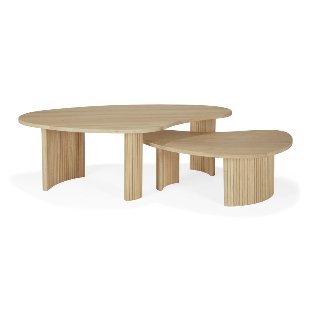 Deux tables basses en bois à la finition lisse et légère. La plus grande table est de forme ovale, tandis que la plus petite table a une forme unique en forme de boomerang. Les deux présentent des rainures verticales sur leurs pieds, mettant parfaitement en valeur leur essence de chêne naturel.