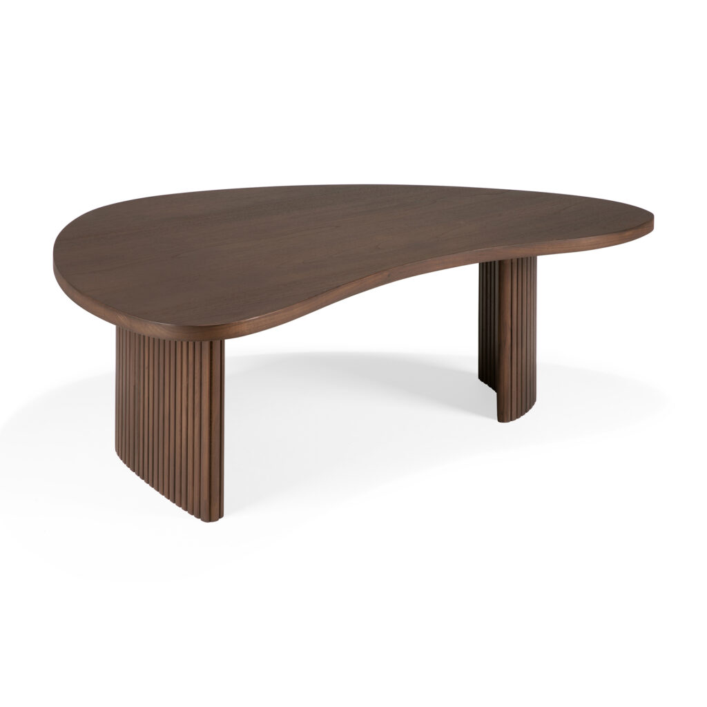 Une table basse asymétrique en bois sombre avec un plateau lisse et deux pieds en planches rainurées verticalement, rappelant une forme de boomerang, fabriquée à partir de teck exquis.