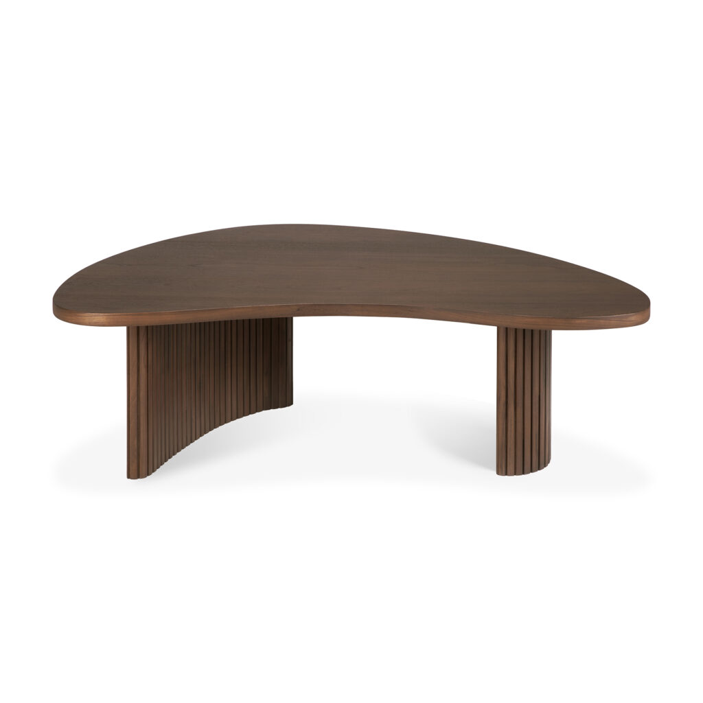 Une table basse moderne en bois marron foncé avec un plateau incurvé et asymétrique rappelant un boomerang et deux pieds nervurés.