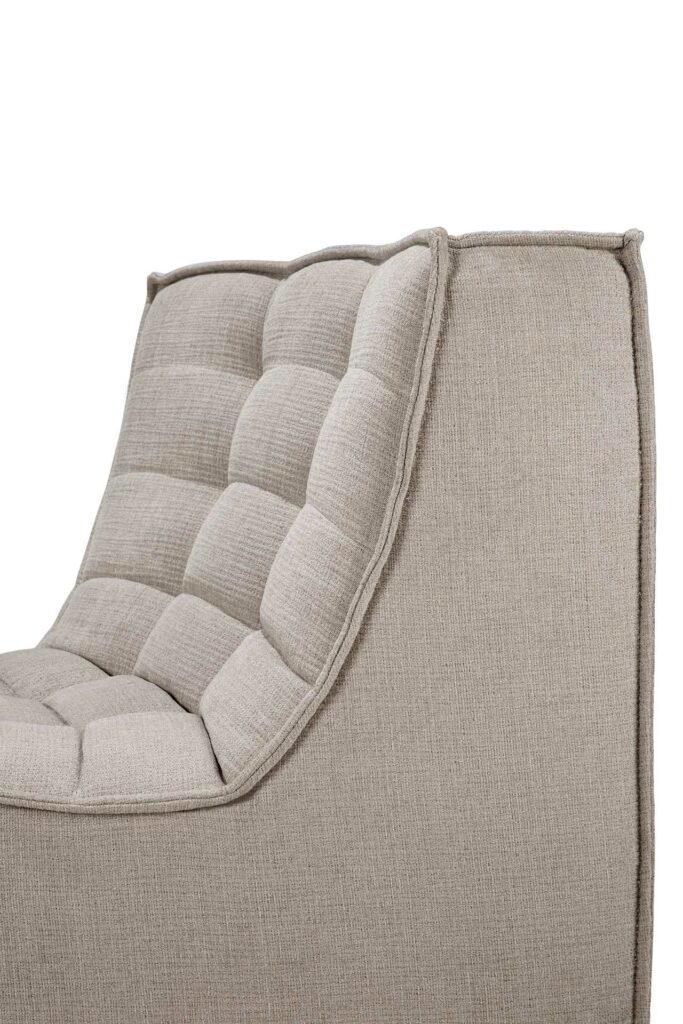 Chaise en tissu beige avec un dossier rembourré et capitonné et un design minimaliste qui complète toute configuration de canapé modulaire.