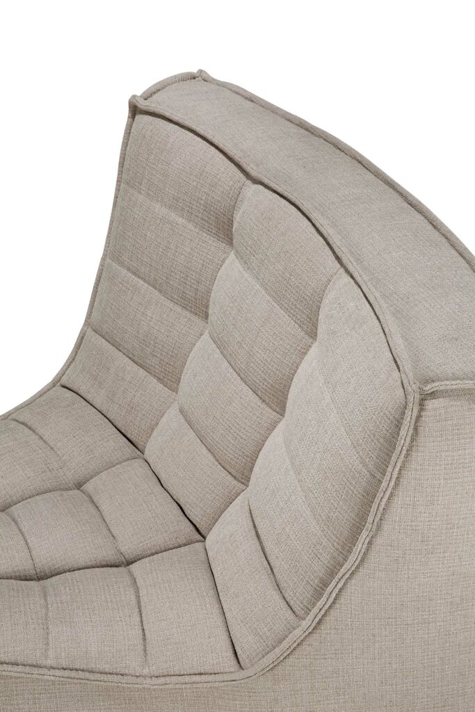 Vue rapprochée d'une chaise rembourrée beige avec dossier et coussins d'assise capitonnés, mettant en valeur sa texture et ses détails de couture, rappelant le luxueux tissu Ecru Eco.