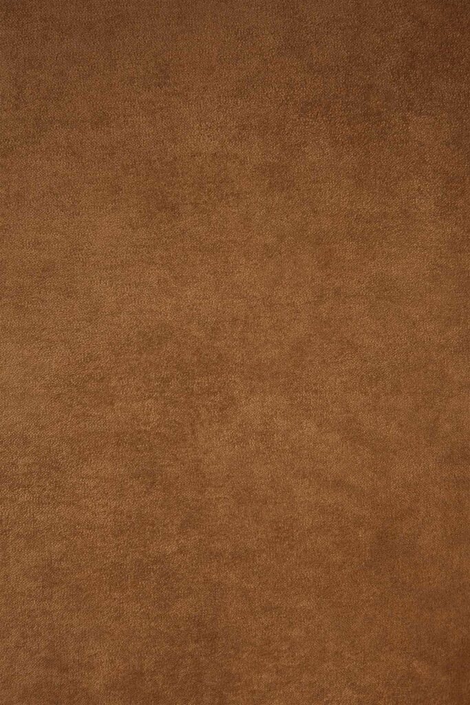 Une vue rapprochée révèle un matériau texturé semblable à du daim marron, ressemblant à un tissu cannelle.