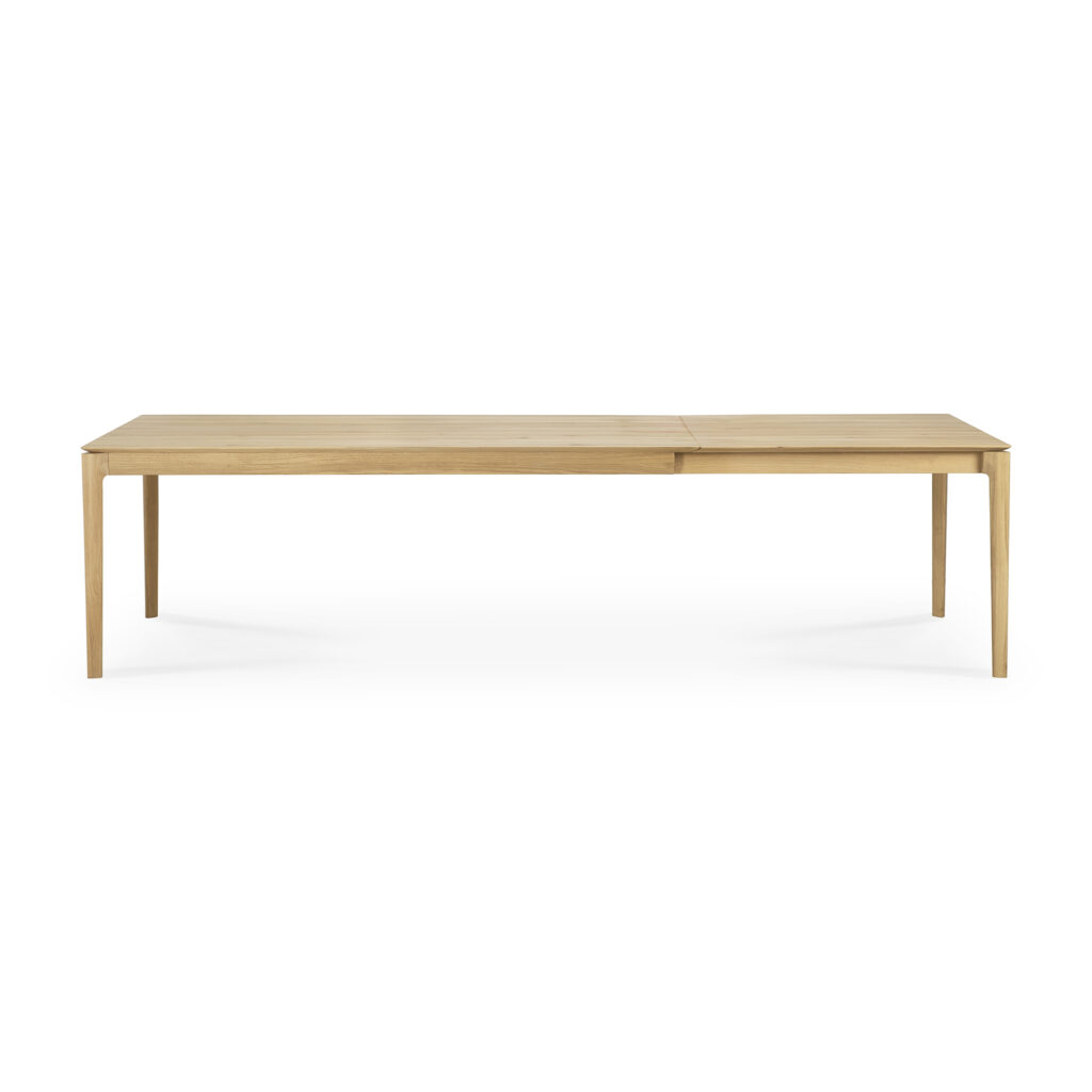 Table rectangulaire en bois au design minimaliste, dotée de pieds fins et d'une surface lisse, la Table Bok dispose également d'une rallonge en chêne extensible, parfaite pour accueillir 200 à 300 convives.