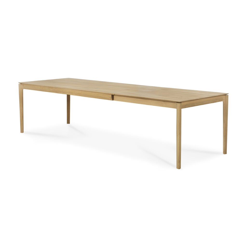 La table Bok présente un long design rectangulaire en bois avec des pieds minces et une surface lisse. Ses dimensions élégantes en font un choix parfait pour n'importe quel espace salle à manger, et il comprend une rallonge en chêne en option pour les réunions prolongées.