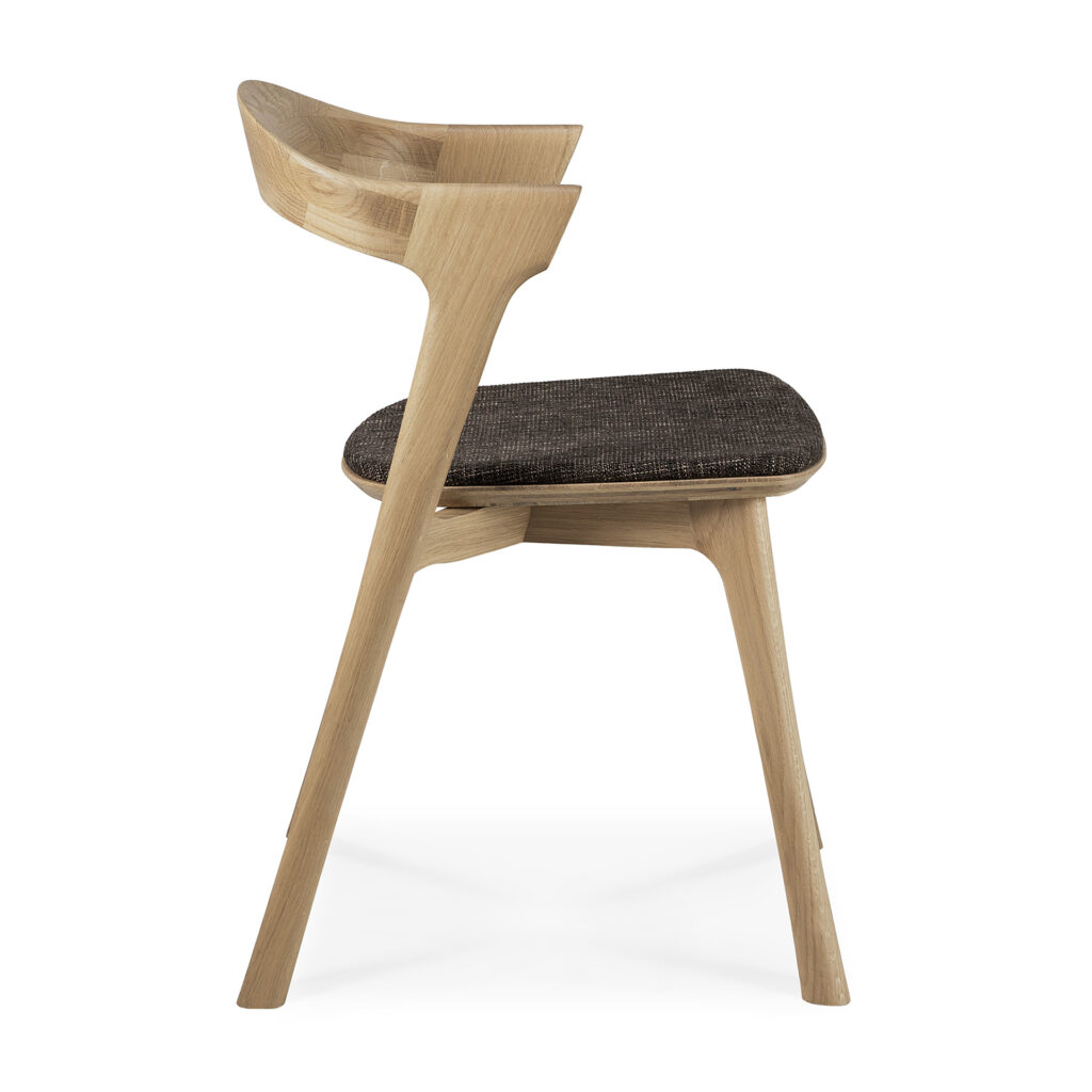 Vue latérale d'une chaise moderne en bois marron foncé avec un dossier incurvé et un siège rembourré noir.