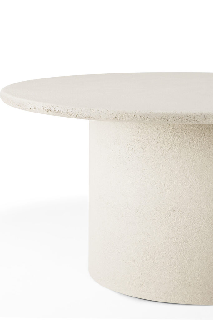 Table Elements est une table ronde, blanc cassé, avec une surface texturée, une base cylindrique épaisse et un plateau plat et lisse, présentée sur un fond blanc.