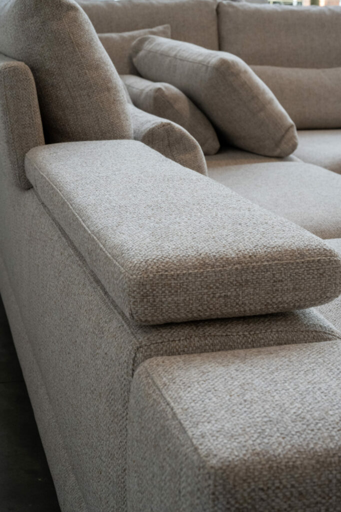 Gros plan d'un canapé sectionnel moderne en tissu gris de la collection Horizon [3,5z +L2Hz] - C50 Reserve 4192, présentant plusieurs coussins et accoudoirs pour un design élégant.