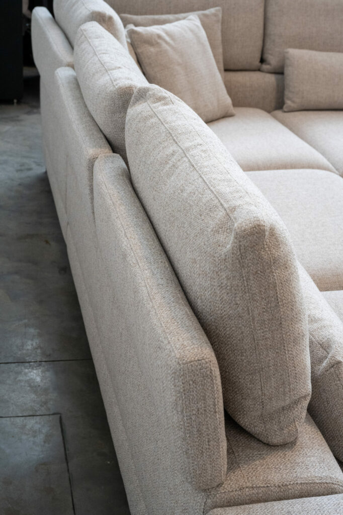 Vue latérale de l'Horizon [3,5z +L2Hz] - C50 Reserve 4192 en sellerie gris clair avec coussins, élégamment posé sur un sol en béton, mettant en valeur son design épuré de pieds col.