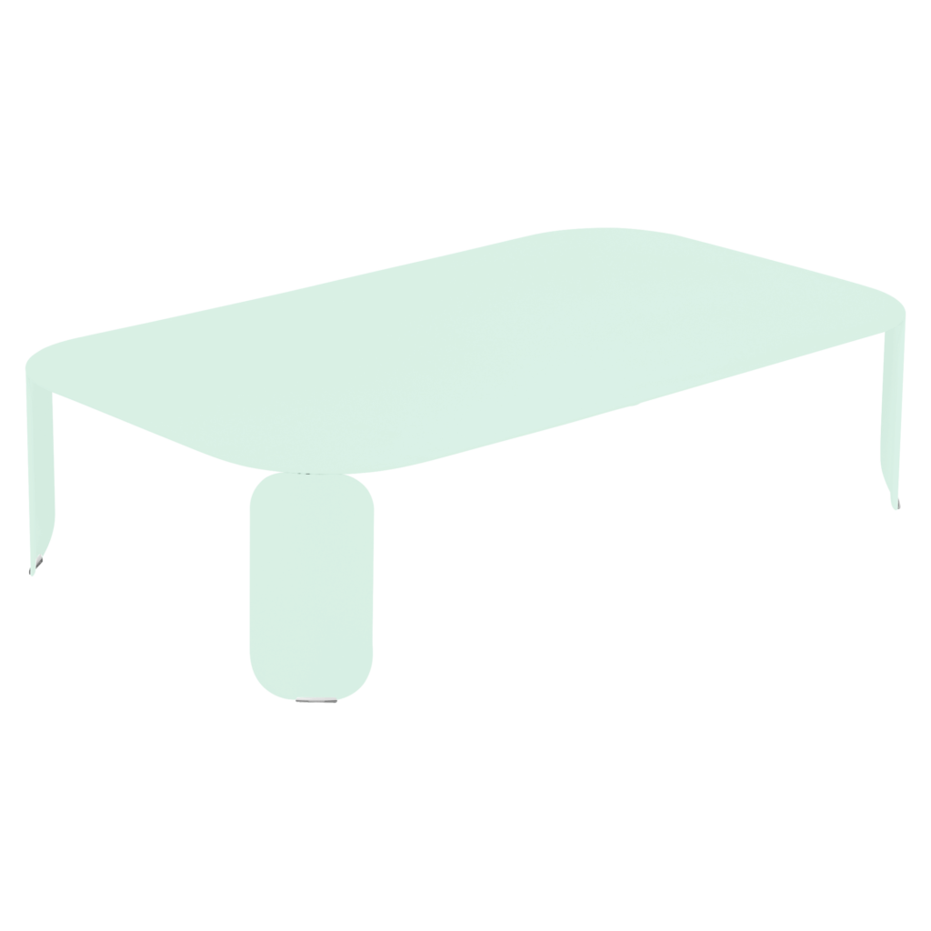 Une table basse rectangulaire de couleur claire avec une nappe vert tilleul drapée dessus, sur un fond noir uni.