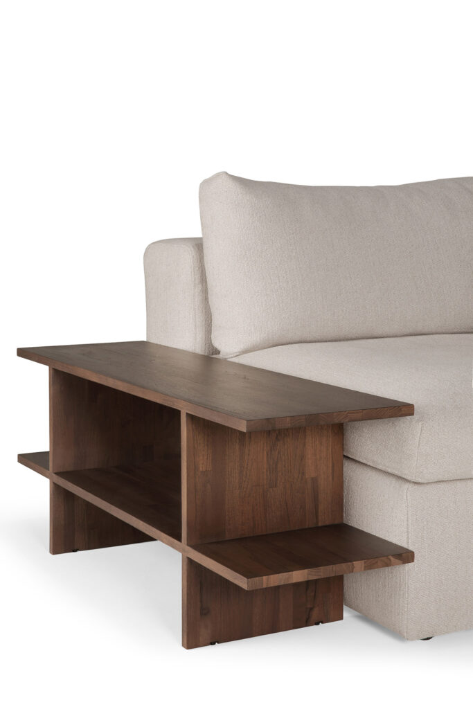 Un canapé rembourré beige doté d'une table d'appoint Kabuki intégrée avec deux étagères dans une finition foncée.