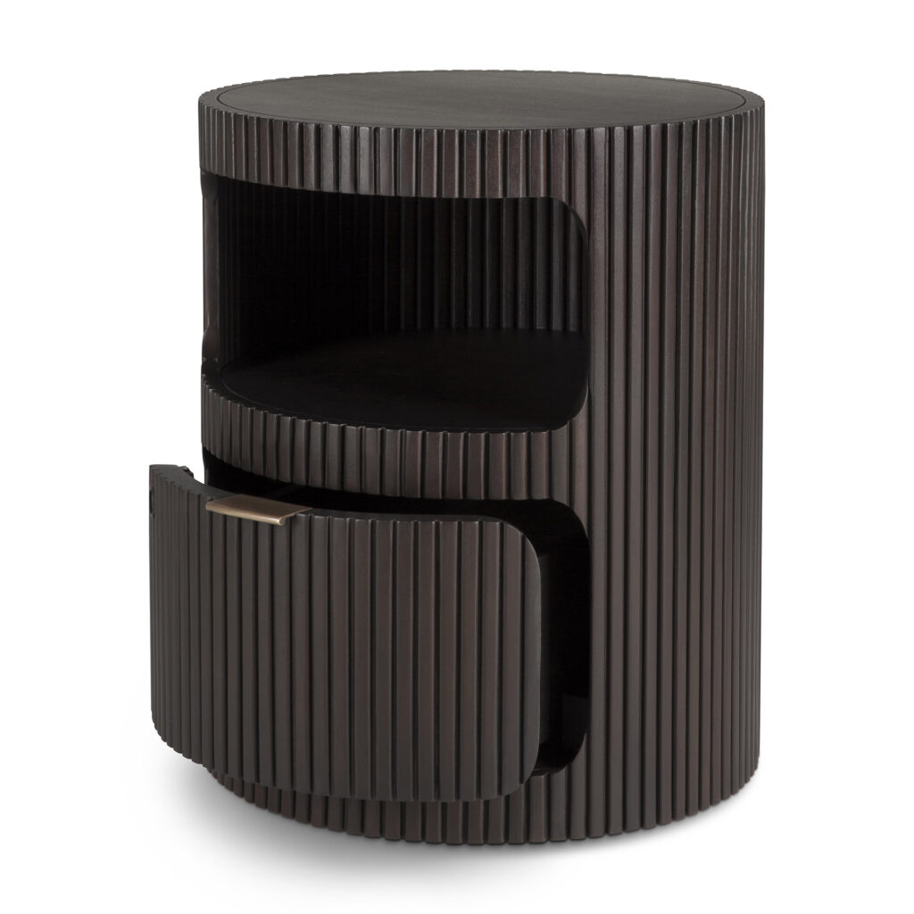 Le bloc-tiroirs Boomerang présente un design rond et moderne avec un extérieur texturé côtelé foncé, une étagère ouverte au milieu et un tiroir distinctif en forme de boomerang en bas qui est représenté partiellement ouvert.