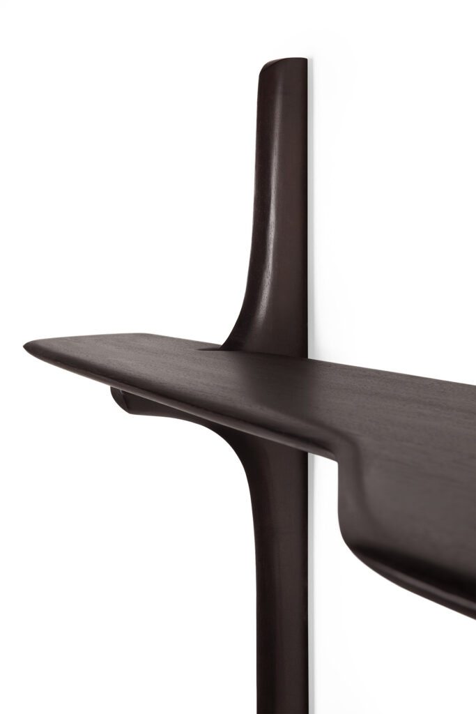 Gros plan d'une étagère en bois foncé au design épuré et moderne, ressemblant au bureau mural PI, montée sur un mur.