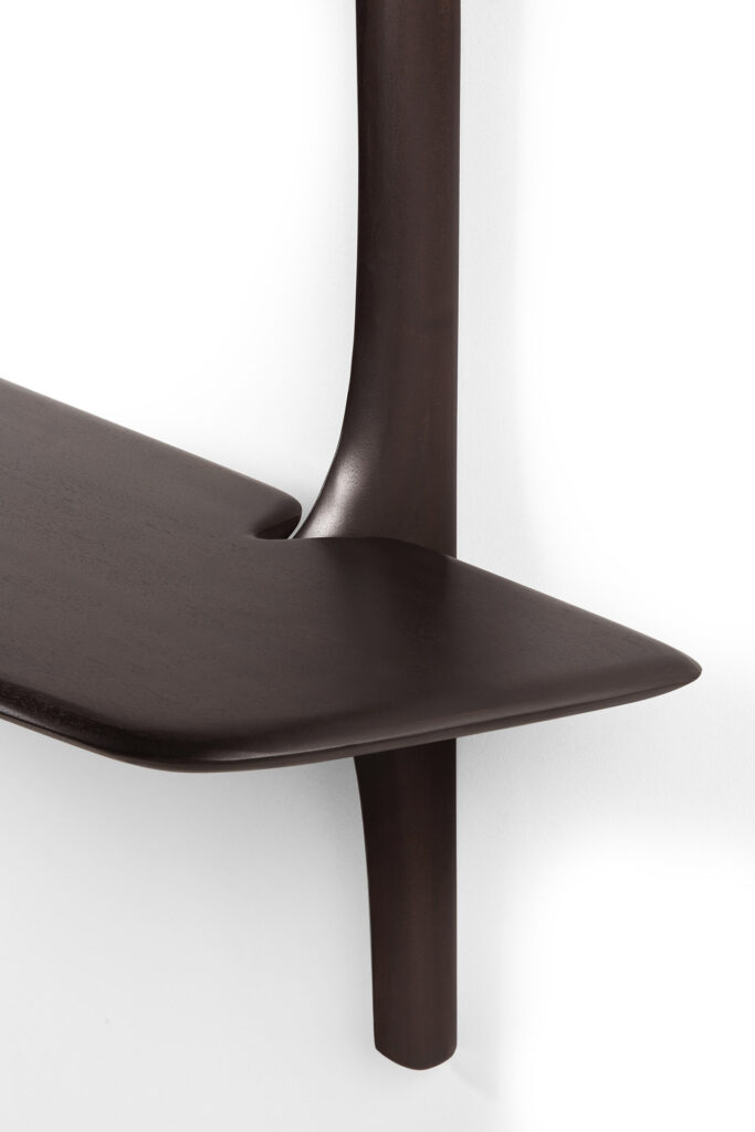 Gros plan du bureau mural PI en bois foncé avec une finition lisse. Le bureau se fond harmonieusement avec la poutre verticale de soutien sur un fond blanc.