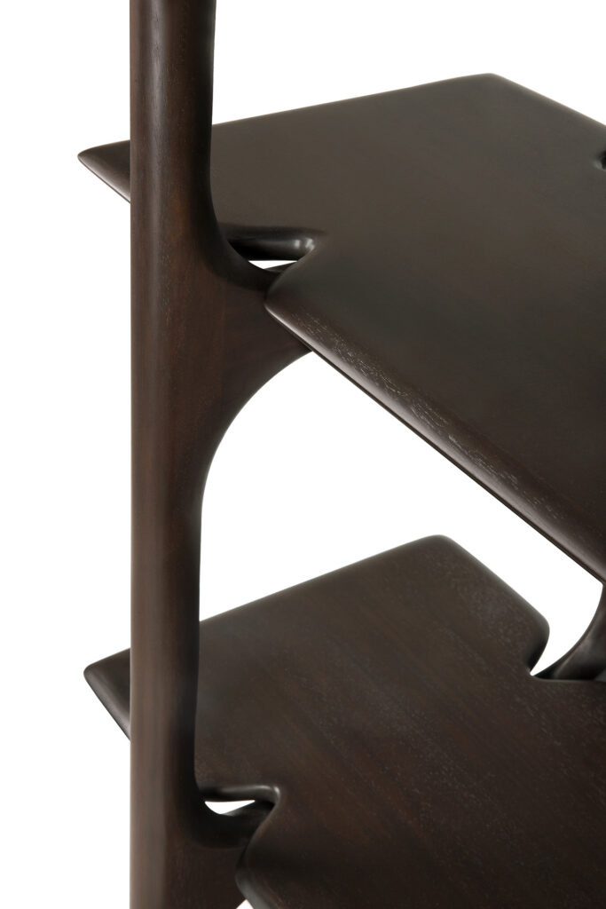 Gros plan du rack PI, une étagère en bois foncé avec des bords lisses et arrondis et des découpes de forme irrégulière entre les étagères, offrant une solution de rangement élégante.