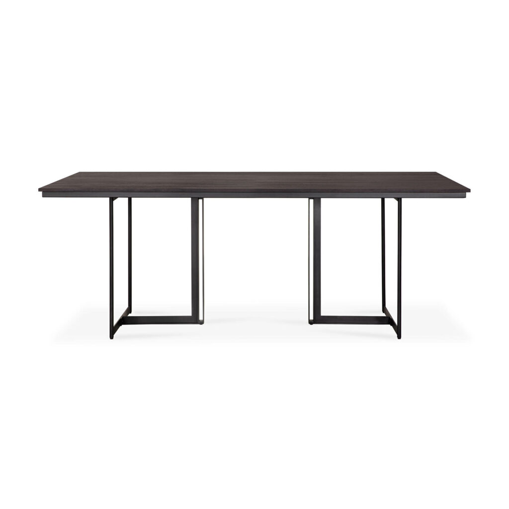 La table à manger Tacet combine une surface rectangulaire en bois minimaliste avec une finition sombre et des pieds en métal noir élégants.