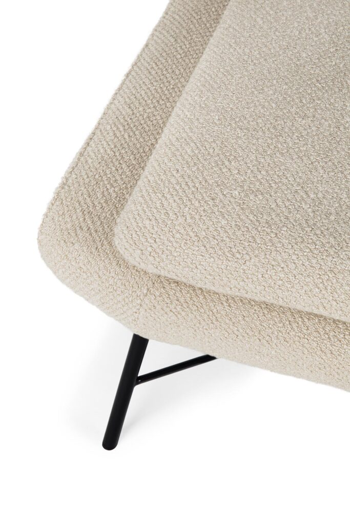 Gros plan d'une chaise Barrow rembourrée de couleur crème avec pieds en métal. Le tissu présente un aspect texturé et tissé qui se marie harmonieusement avec l'élégant repose-pieds Barrow.