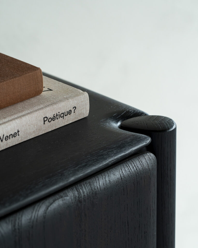 Un livre à couverture marron et un autre intitulé "Poétique ?" reposent sur un buffet PI en bois foncé - 3 portes, aux bords arrondis.