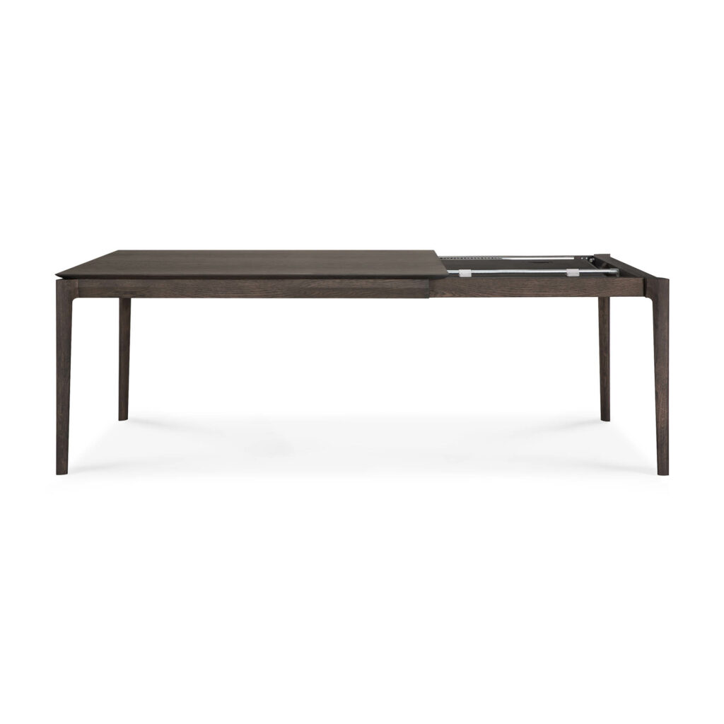 Cette charmante table à manger extensible Bok, mesurant 140 cm, présente un design rectangulaire en bois avec un mécanisme d'extension partiellement ouvert, soutenu par quatre pieds fins.
