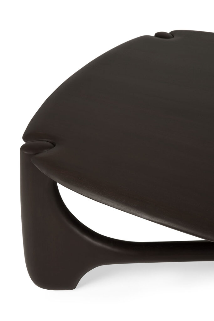Vue rapprochée d'une table basse PI avec une surface en bois foncé, une teinture Acajou, des bords lisses et incurvés et un design de pieds unique et moderne.