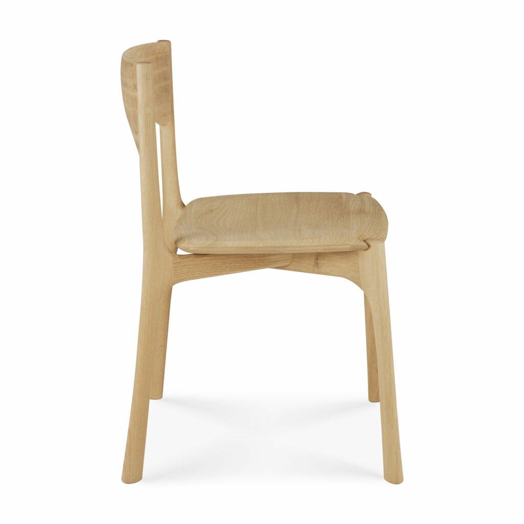 Vue de côté de la chaise de salle à manger PI avec un dossier légèrement incurvé et quatre pieds. La chaise a un design minimaliste et une finition en bois de chêne huilé.
