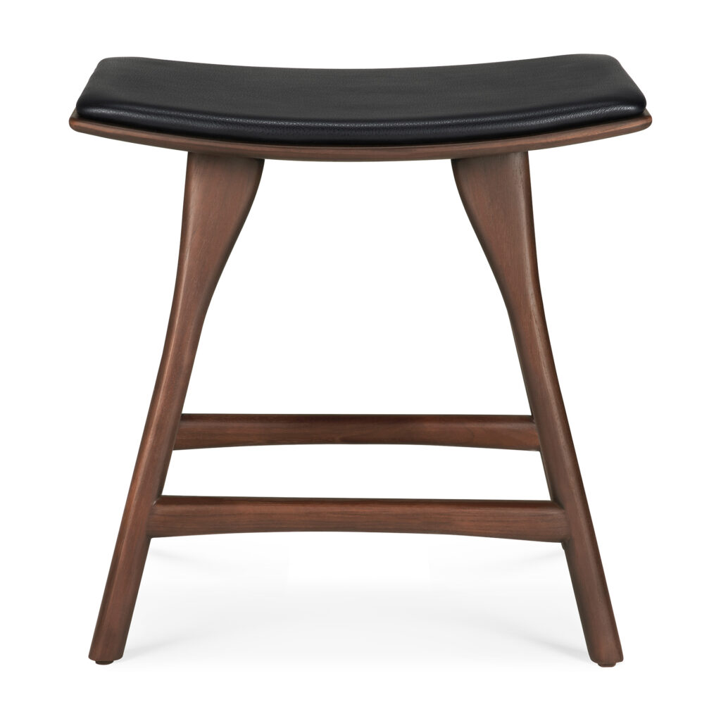 Le Tabouret Osso est un tabouret en bois avec une finition teck teinté brun, doté d'une assise courbée avec rembourrage en cuir noir, de deux pieds et d'une barre transversale pour le soutien.