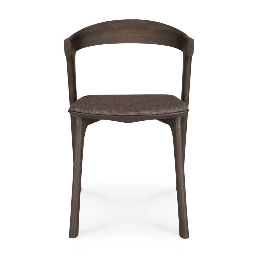Chaise en bois marron chaleureux avec dossier incurvé et assise rembourrée. La chaise de salle à manger Bok possède quatre pieds et un design simple et moderne, parfait pour toute salle à manger.