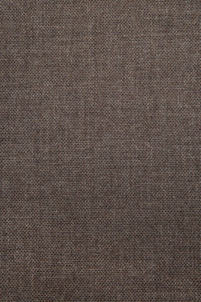 Vue rapprochée d'un tissu marron texturé avec un motif tissé, capturant l'essence chaleureuse rappelant une chaise de salle à manger Bok en marron chaud.