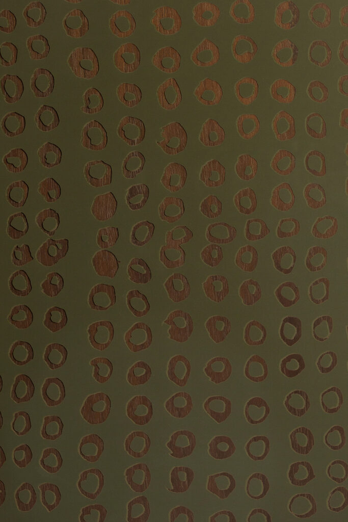 Un motif de formes circulaires irrégulières de couleur marron, rappelant le plateau en verre mousse Seconde Nature - rond - S, disposées en lignes verticales sur un fond vert foncé.